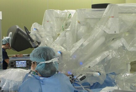 術者はサージョンコンソールを操作します。下の写真は、画面奥が、術者とサ-ジョンコンソール。手前が助手とペーシェントカート(ロボットアーム)。